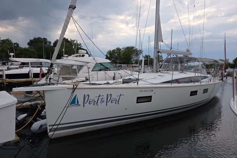 2020 Jeanneau 54 sailboat docked at marina, named "Port to Port," under cloudy sky.