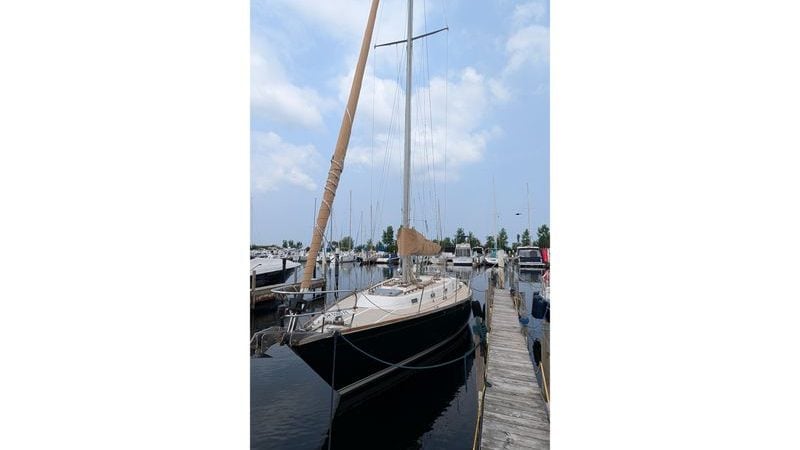 1985 Tartan 37 sailboat docked at a marina under a clear blue sky.