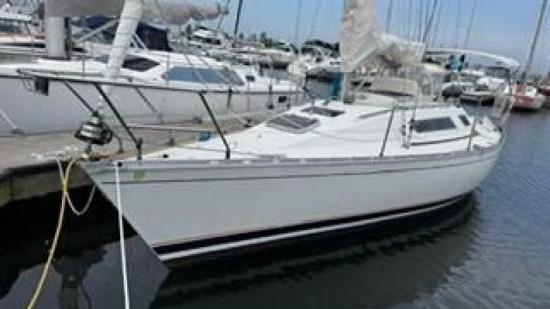 1986 Beneteau First 305 sailboat docked in a marina.