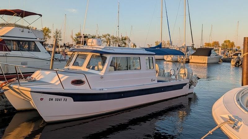 2020 C-Dory 25' Tomcat Catamaran docked at marina during sunset.