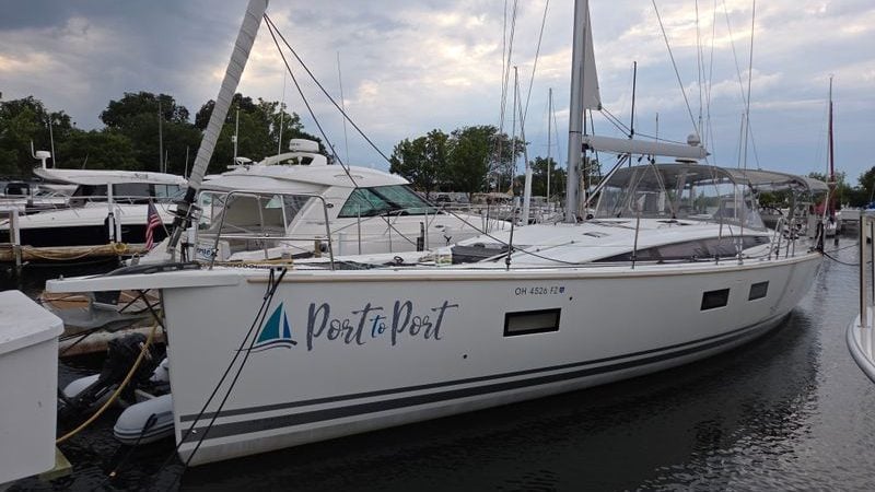 2020 Jeanneau 54 sailboat docked at marina, named "Port to Port," under cloudy sky.