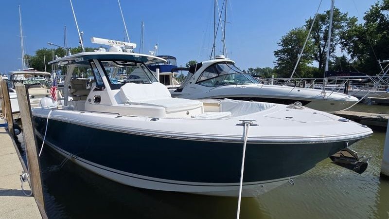 2020 Pursuit S 368 Sport boat docked at marina under clear blue sky.