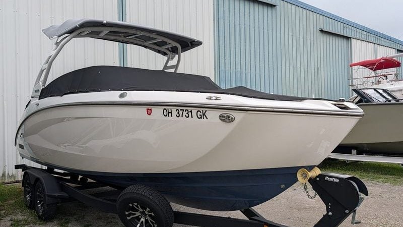 2023 Yamaha Boats 252SD on trailer, parked outside a warehouse.