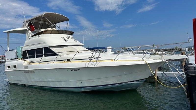 1995 Silverton AFT CABIN yacht docked in marina under blue sky.